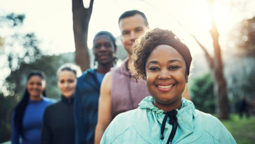 A picture of four people outside near a tree.